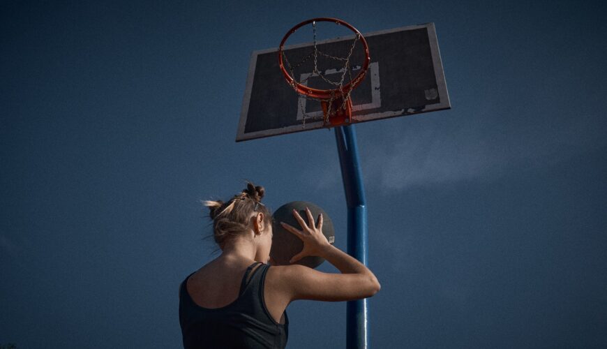 Kobieta gra w koszykówkę w sukience sportowej